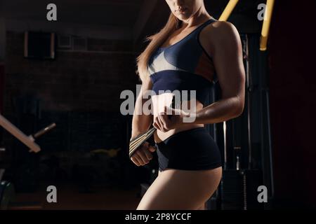 Sportliche Frau mit Armband im modernen Fitnessstudio, Nahaufnahme Stockfoto