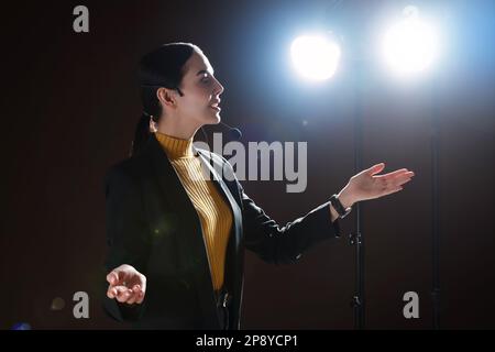 Motivationslautsprecher mit Headset, das auf der Bühne läuft Stockfoto