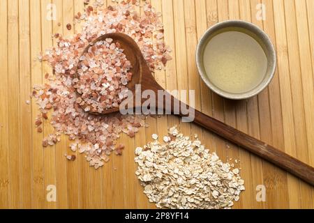 Ein flaches Studiofoto eines himalaya-Meersalzes mit einem Löffel, einem Haufen getrocknetem Haferfleisch und einer kleinen Schüssel mit Olivenöl. Stockfoto