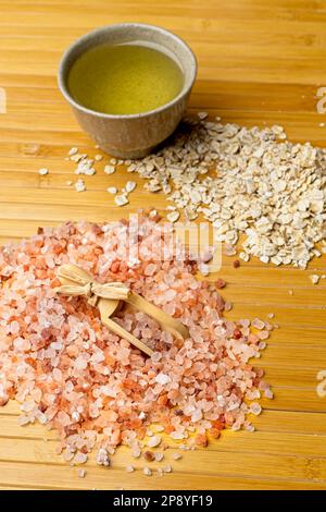 Ein flaches Studiofoto eines himalaya-Meersalzes mit einer Schaufel, eines Haufens getrockneten Haferfleisches und einer kleinen Schüssel mit Olivenöl. Stockfoto