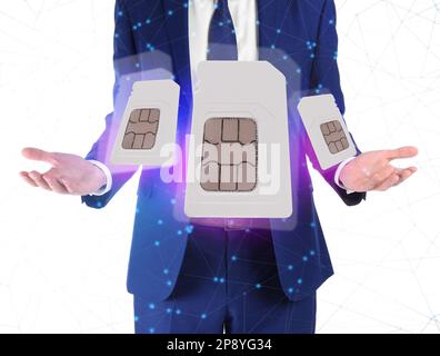 Ein Mann, der SIM-Karten verschiedener Größen auf weißem Hintergrund vorführt, Nahaufnahme Stockfoto