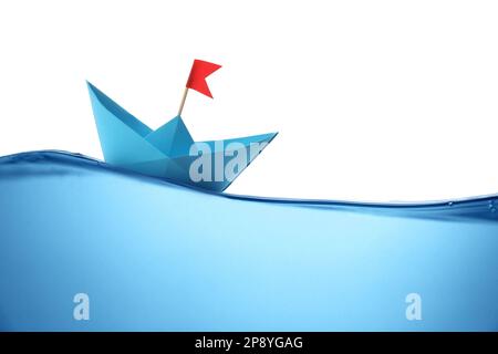 Handgefertigtes blaues Papierboot, das auf klarem Wasser vor weißem Hintergrund schwimmt Stockfoto