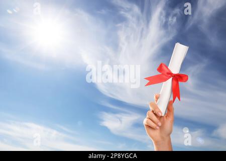 Absolvent mit Diplom gegen den blauen Himmel an einem sonnigen Tag, Schließung Stockfoto