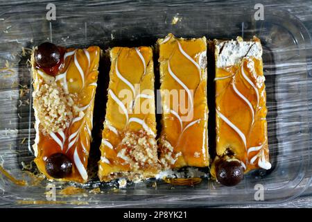 Ägyptisches Dessert aus Schichten von Basbousa-Grießtorte, Kunafa-Knafeh, Schlagsahne, Karamellsauce zusammen getränkt in süß und mit Nüssen überzogen, Stockfoto