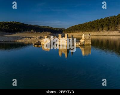 Blick aus der Vogelperspektive auf ein altes Haus in Ruinen, das durch den niedrigen Wasserstand des Sant Ponc Reservoirs (Solsonès, Lleida, Katalonien, Spanien) geschützt ist Stockfoto