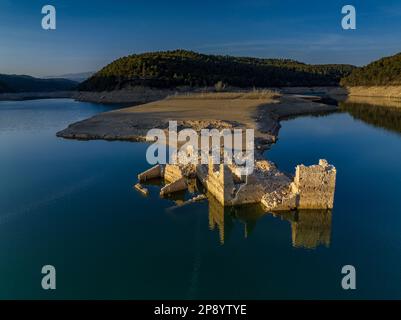 Blick aus der Vogelperspektive auf ein altes Haus in Ruinen, das durch den niedrigen Wasserstand des Sant Ponc Reservoirs (Solsonès, Lleida, Katalonien, Spanien) geschützt ist Stockfoto