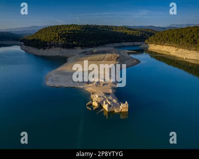 Blick aus der Vogelperspektive auf ein altes Haus in Ruinen, das durch den niedrigen Wasserstand des Sant Ponc Reservoirs (Solsonès, Lleida, Katalonien, Spanien) geschützt ist Stockfoto