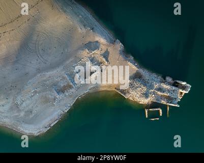 Blick aus der Vogelperspektive auf ein altes Haus in Ruinen, das durch den niedrigen Wasserstand des Sant Ponc Reservoirs (Solsonès, Lleida, Katalonien, Spanien) geschützt ist Stockfoto