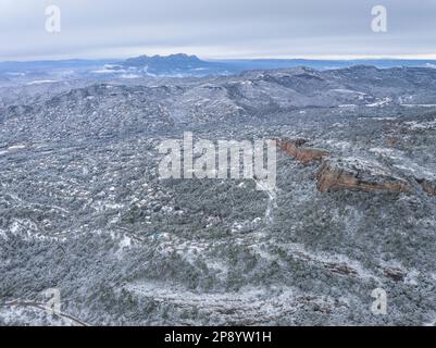 Blick aus der Vogelperspektive auf die schneebedeckten Dörfer Montserrat und Matadepera nach dem Schneefall von 02-27-2023 (Vallès Occidental, Barcelona, Katalonien, Spanien) Stockfoto