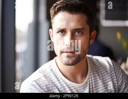 Diese Augen können in deine Seele sehen. Porträt eines attraktiven jungen Mannes, der in einem Café sitzt. Stockfoto