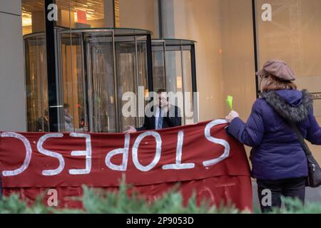 NEW YORK, NEW YORK - MÄRZ 09: Ein Mann mit Telefongesicht protestierte mit einem Banner vor dem Gebäude der New York City Büros von JPMorgan Chase & Co. Während eines Protests gegen den vorgeschlagenen Cop City, der am 09. März 2023 in einem Atlanta Wald in New York City gebaut wurde. COP City, eine riesige Polizeiausbildungseinrichtung, die auf einem Waldgebiet im Raum Atlanta, Georgia, im Bau ist, ist zu einem Schwerpunkt der Demonstrationen geworden, die der Entwicklung in einem der unberührtesten Wälder des Bundesstaates entgegenstehen. Das $90-Millionen-Dollar-Ausbildungszentrum soll die Polizei in militarisierter städtischer Kriegsführung ausbilden. Stockfoto