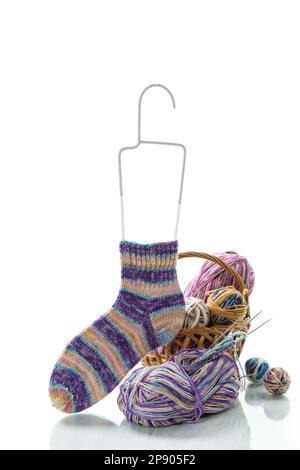 Farbige Fäden, Stricknadeln und andere Artikel zum Handstricken, isoliert auf weißem Hintergrund. Stockfoto