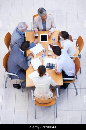 Die Tabelle, in der Entscheidungen getroffen werden. Blick auf eine Gruppe von Geschäftsleuten, die eine Besprechung an einem Konferenztisch abhalten. Stockfoto
