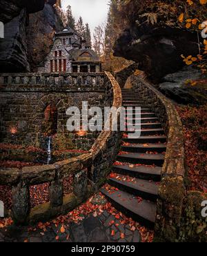 Hresko, Tschechische Republik - im Herbst gibt es in den tschechischen Wäldern in der Nähe von Hresko eine wunderschöne, geschwungene Steintreppe und ein Steinhaus mit bunten Herbstblättern Stockfoto