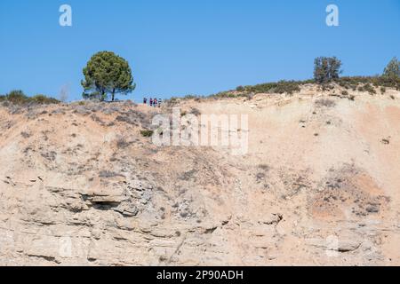 Menschen am Aussichtspunkt, alter Steinbruch, Aspekt des verlassenen Steinbruchs. An der Mauer des Steinbruchs sind mehrere Erdrutsche zu beobachten. Vilobi del Penedes Stockfoto