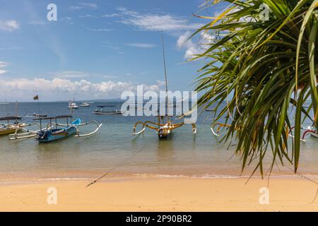 Traditionelle indonesische Fischerboote im Outrigger-Stil (Jukung) am Strand in Sanur, Bali, Indonesien. Stockfoto