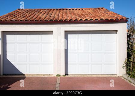 Fassade, neues modernes Doppelzimmer, zwei Garagen, weiße Haustür eines Wohnhauses Stockfoto