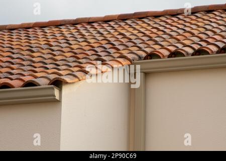 Metallrinne in Braun an der Fassade Beige Dach bedeckt mit Keramikfliesen Nahaufnahme Stockfoto