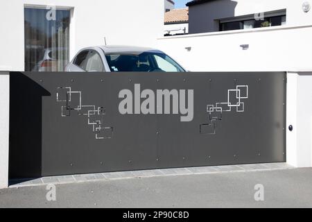 Moderne, dunkelgraue Schiebetür aus Aluminium mit hohem, grauen Türdesign für den Außenbereich Stockfoto