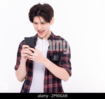 Junge asiatische Schülerin, die lacht und auf das Smartphone schaut Stockfoto