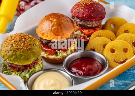 Drei Mini-Burger mit Huhn und Fleisch serviert mit pommes frites. Kindermenü Stockfoto