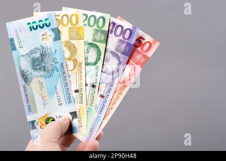 Philippinisches Geld - Peso auf grauem Hintergrund Stockfoto