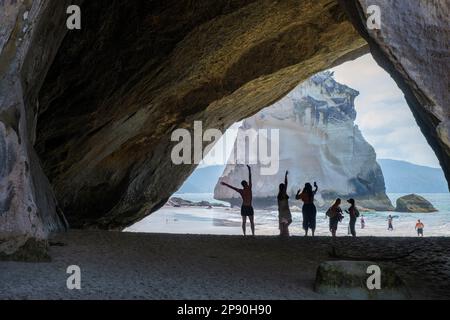 Touristen posieren für Fotos in Cathedral Cove, Coromandel Peninsula, North Island, Neuseeland Stockfoto