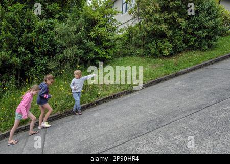 Kinder gehen die steilste Straße der Welt entlang - Baldwin Street, Dunedin, South Island, Neuseeland Stockfoto