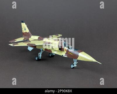 Soligorsk, Weißrussland - 7. Januar 2023: Modell des englisch-französischen Jet-Angriffsflugzeugs Sepecat Jaguar in militärischer Tarnung auf braunem Hintergrund, selektiv für Stockfoto