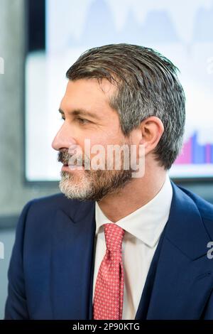 Porträt eines gravierenden, grauhaarigen Geschäftsmanns im formellen Anzug und mit Krawatte, der während einer Besprechung in einem modernen Büro nachdenklich wegblickt Stockfoto