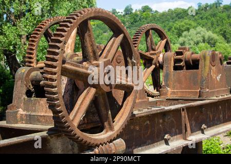 Alte mechanische Metallgetriebemechanik am verlassenen Damm. Stockfoto