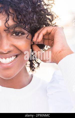 Schneide ein Bild mit einer halbherzigen Gesichtskomposition mit einem attraktiven, großen schwarzen Mädchen, das auf weißem Hintergrund in die Kamera schaut. Afro-Model-Frau, Kopfschuss. Kontra Stockfoto