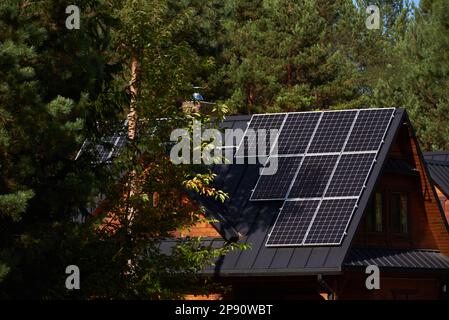 Photovoltaikanlage auf den Dächern von Holzhäusern im Wald Stockfoto