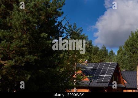 Photovoltaikanlage auf den Dächern von Holzhäusern im Wald Stockfoto