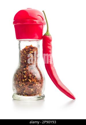 Trockene Chili-Pfefferflocken. Zerkleinerte rote Paprika in der Mühle und frische rote Paprika, isoliert auf weißem Hintergrund. Stockfoto