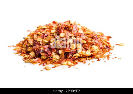 Trockene Chili-Pfefferflocken. Zerkleinerte rote Paprika, isoliert auf weißem Hintergrund. Stockfoto