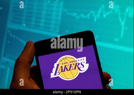 China. 15. Februar 2023. In dieser Fotoabbildung ist das Logo des Los Angeles Lakers-Teams auf einem Smartphone zu sehen. Im Hintergrund ist ein Diagramm mit einem Index der wirtschaftlichen Börse zu sehen. (Kreditbild: © Budrul Chukrut/SOPA Images via ZUMA Press Wire) NUR REDAKTIONELLE VERWENDUNG! Nicht für den kommerziellen GEBRAUCH! Stockfoto