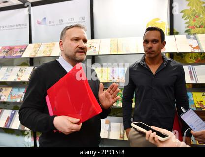 Bologna, Italien. 7. März 2023. Slava Fedorov (L), Chief Executive des russischen IRSI-Verlagshauses, und Carlos Eduardo Cavalheiro Filho, Chief Executive des brasilianischen LTDA von Bom Bom Book, erhalten ein Interview auf der Bologna Children's Book Fair in Bologna, Italien, 7. März 2023. ZUM MOTTO „Feature: Chinesische Geschichten gewinnen die Herzen der Verleger auf der Kindermesse in Italien“: Jin Mamengni/Xinhua/Alamy Live News Stockfoto