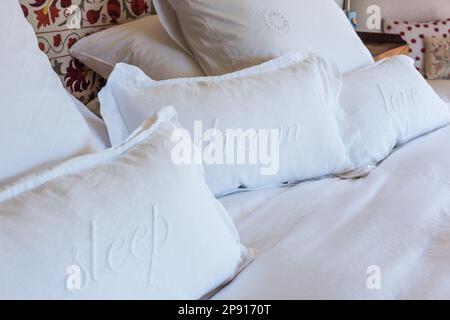 Kissenbezüge mit „Schlaf“, „Traum“, „Liebe“ bestickt, im Herrenhaus von Sussex, Großbritannien Stockfoto