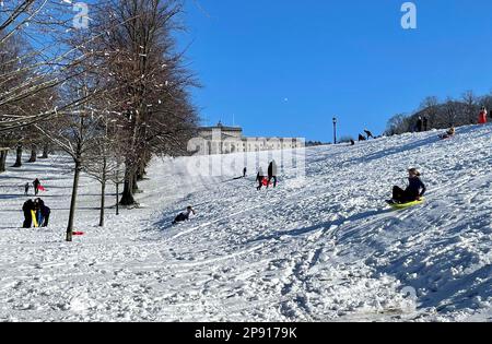 Die Menschen genießen den Schnee auf dem Stormont Estate in Belfast, Nordirland. Foto: Freitag, 10. März 2023. Stockfoto