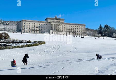 Die Menschen genießen den Schnee auf dem Stormont Estate in Belfast, Nordirland. Foto: Freitag, 10. März 2023. Stockfoto