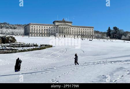 Die Menschen genießen den Schnee auf dem Stormont Estate in Belfast, Nordirland. Foto: Freitag, 10. März 2023. Stockfoto