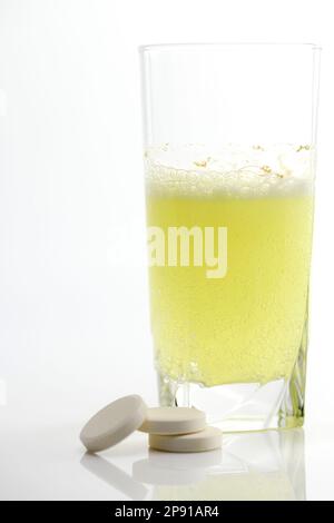 Die Brausetablette löst sich in einem Glas Wasser auf. Nahaufnahme. Stockfoto