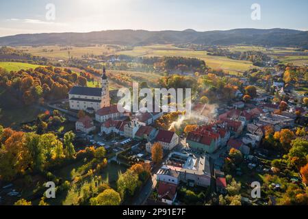 Luftaufnahme des Dorfes Chełmsko Śląskie in Niederschlesien in Polen. Deutlich sichtbare Rauchschornsteine von Wohnhäusern Stockfoto