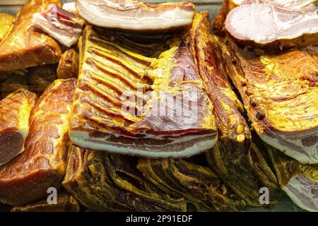Traditionelles jamón oder Prosciutto auf dem Markt. Ganze Stücke geräucherten Schweineschinken in der Metzgerei. Stockfoto