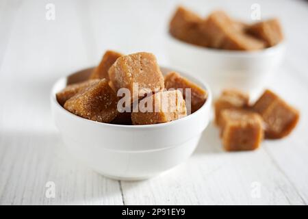 Nahaufnahme von braunem Rohrzucker auf weißem Hintergrund, selektiver Fokus Stockfoto
