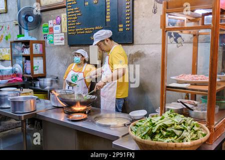 Bangkok Ratchawat Thailand Menschen bereiten thailändisches Street Food an einem Imbissstand mit einem Wok Pfanne Braten zu. Stockfoto