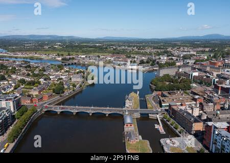 Luftaufnahme des Stadtzentrums von Limerick mit Shannon in der Mitte. Das Foto wurde an einem sonnigen Sommertag aufgenommen. Stockfoto