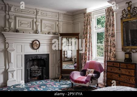 Standspiegel und Sessel im Fenster des Herrenhauses Wiveton Hall aus dem 17. Jahrhundert, Norfolk, Großbritannien Stockfoto