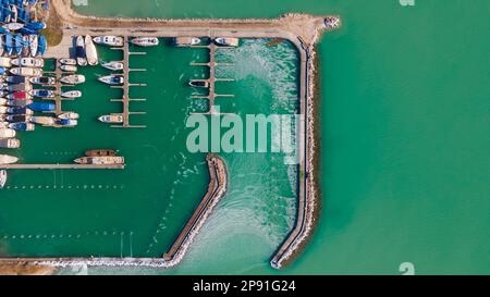 Blick von oben über einen Bootshafen am Balaton Lake, Ungarn. Blick von oben auf den Yachtclub. Drohnenansicht. Segelboote legen an. Grüner See. Stockfoto